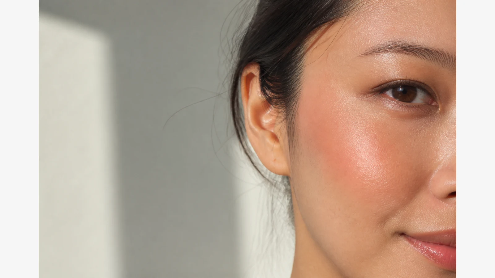 Close-up of cheek with sheer dewy blush blended toward the temple in daylight